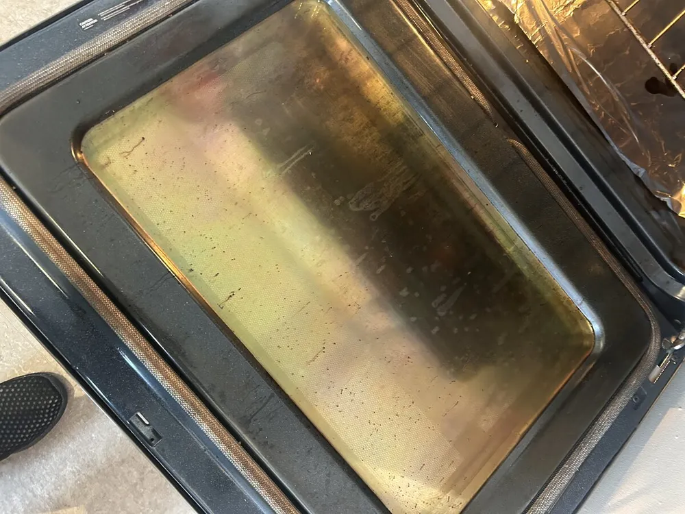 Greasy oven door before cleaning