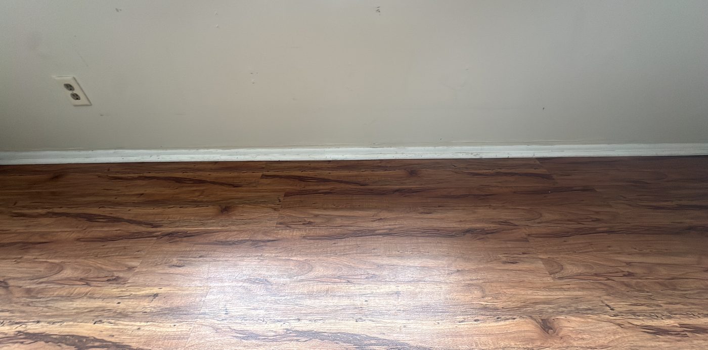 Cleaned floor meeting white baseboards beside a doorway