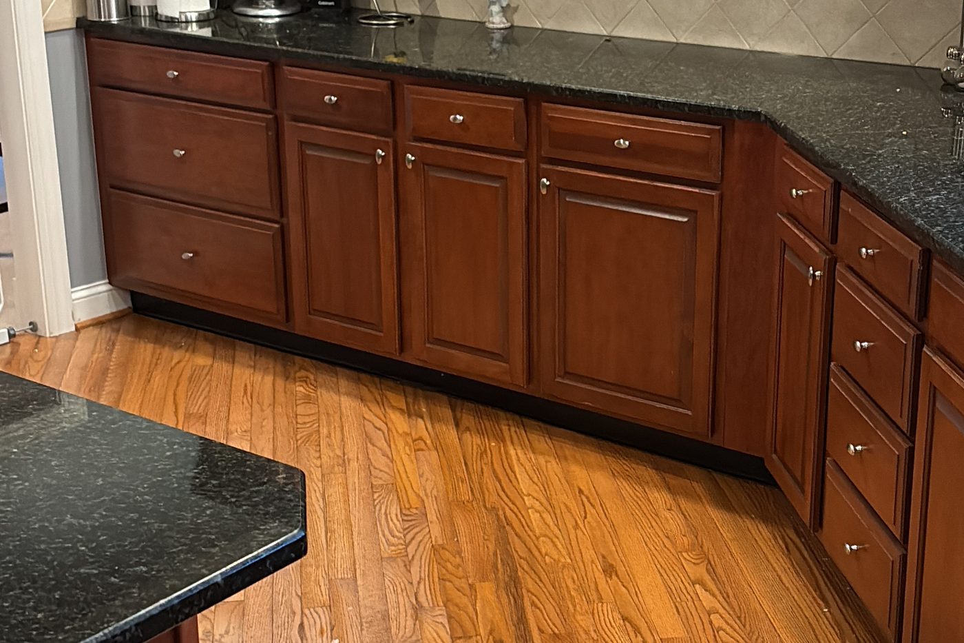 House cleaning in a Columbus kitchen Cleaned kitchen with cherry cabinet fronts, dark granite counters and polished hardwood flooring in a Columbus home