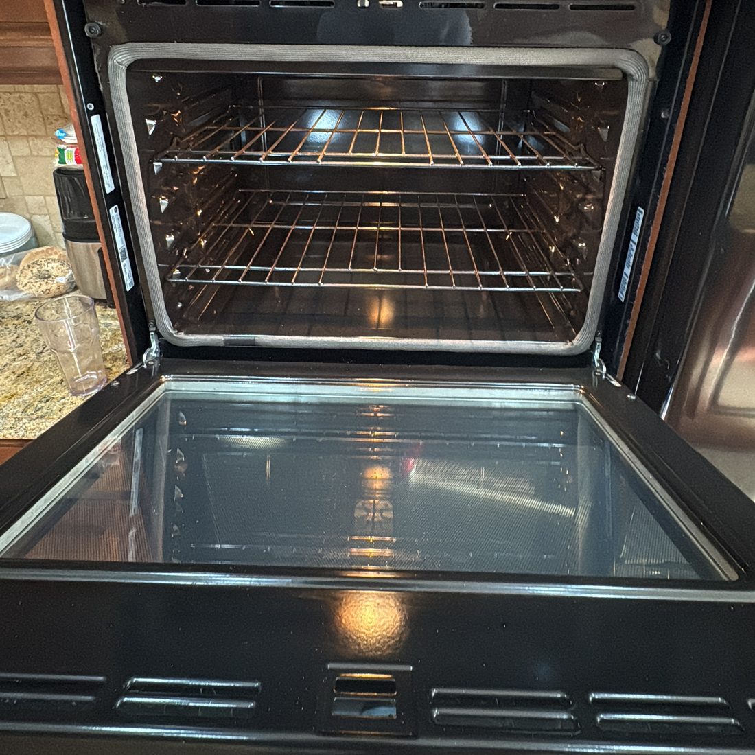 Oven interior after a deep-clean wipe-down Open wall oven showing a cleaned interior cavity, bright racks and clear door glass
