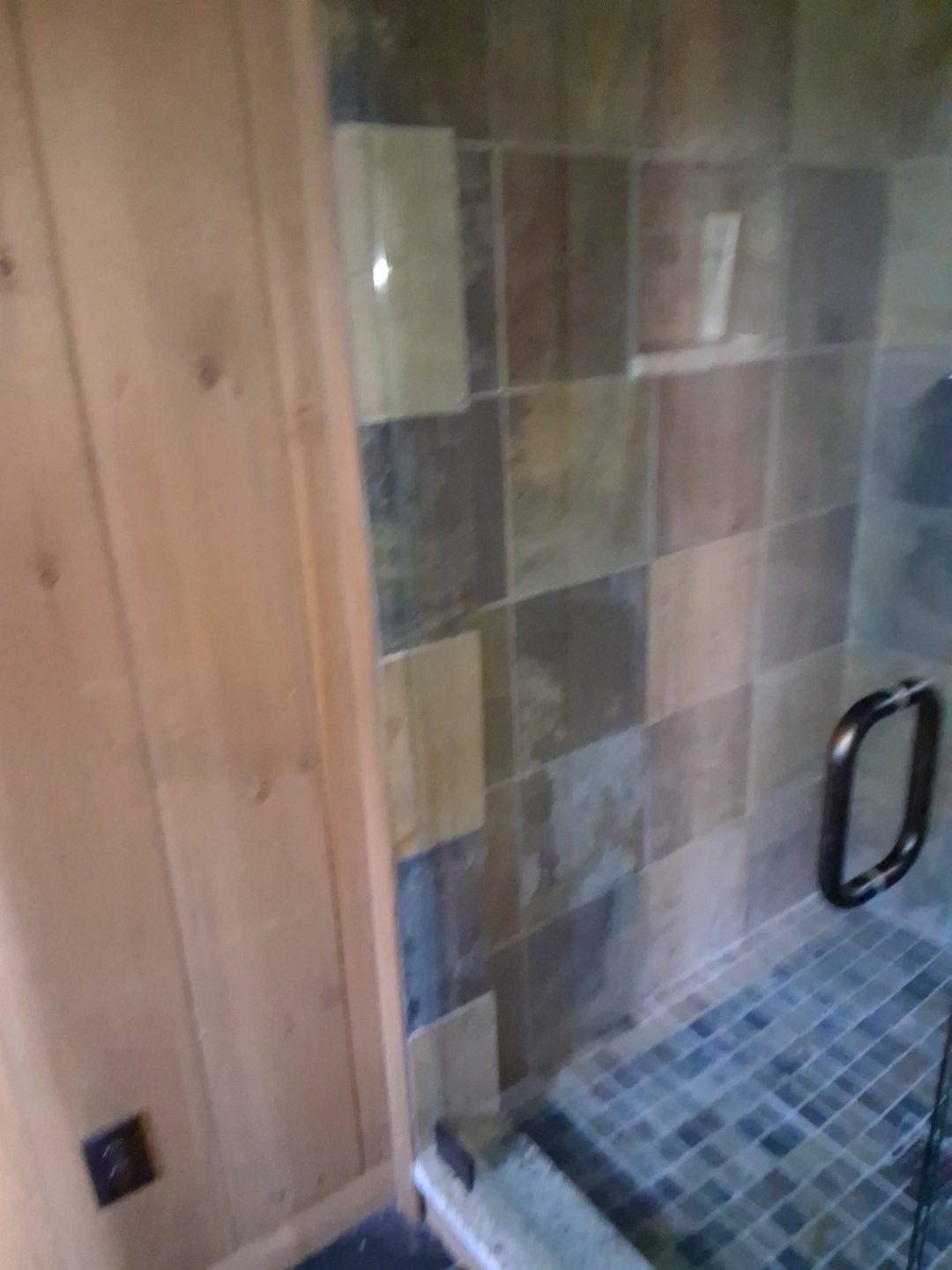 Tile shower detail after final cleaning Stone tile shower wall and glass door edge after final detail cleaning