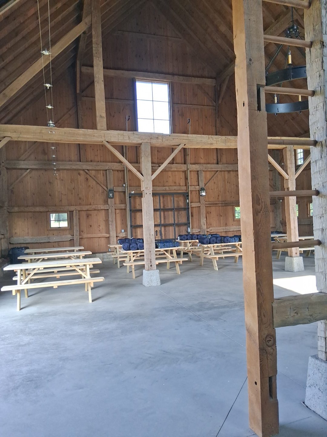 Construction stage, before cleaning Timber-frame interior during construction with exposed framing, work benches and a bare concrete floor